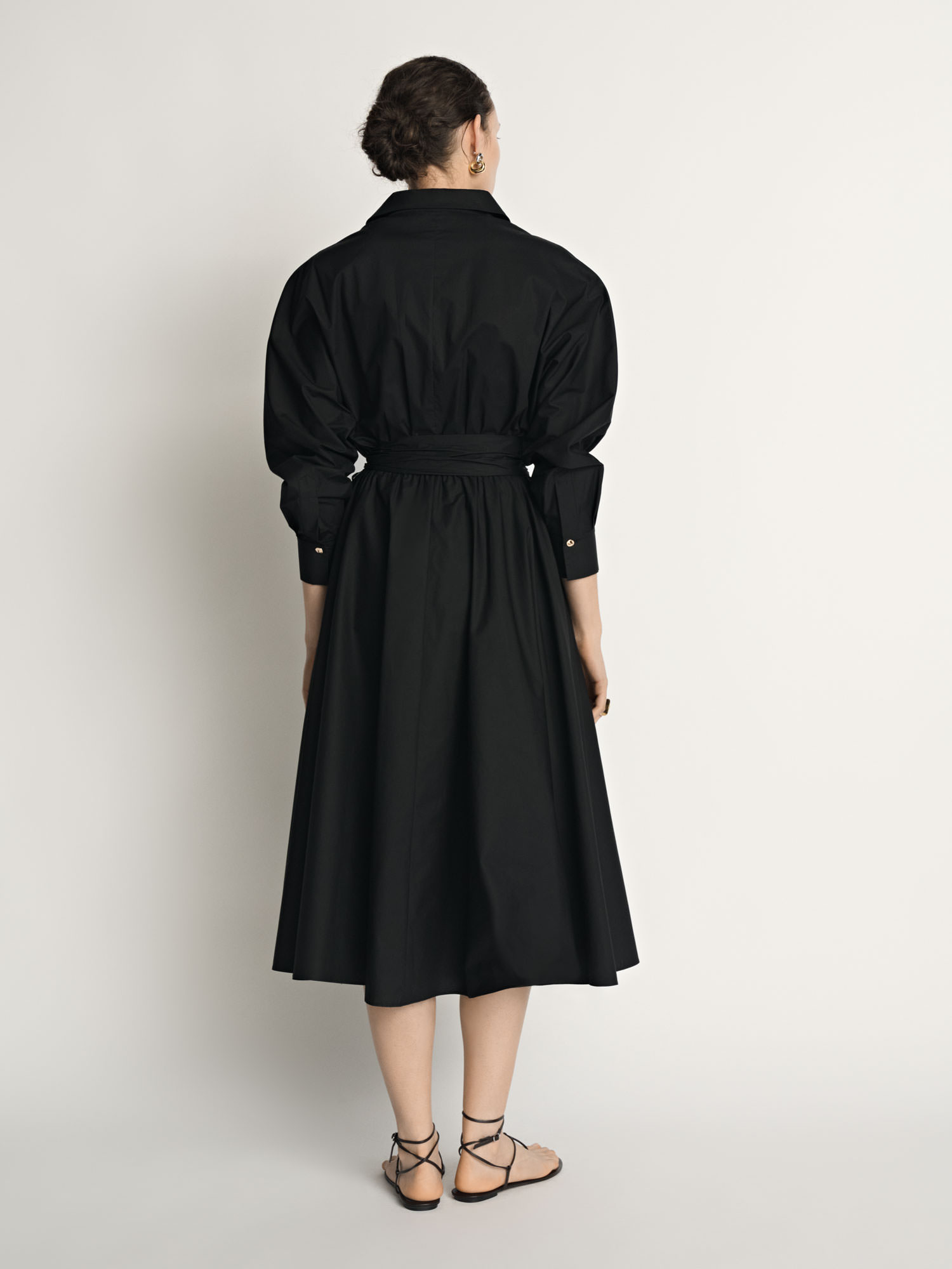 Back view of a model wearing a black Veronika Maine shirt dress photographed for fashion e-commerce.