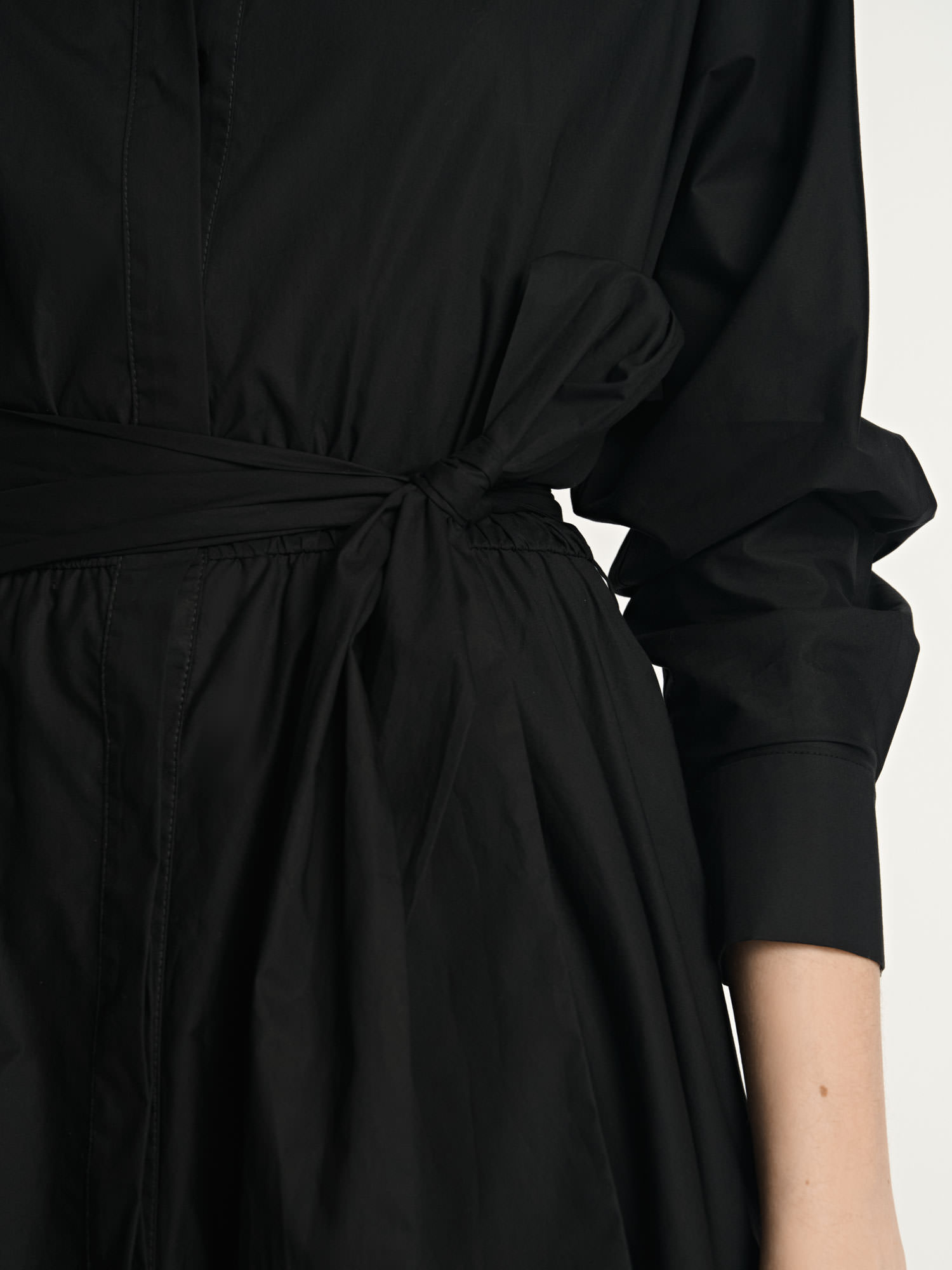 Close-up detail of the waist tie on a black Veronika Maine shirt dress photographed for fashion e-commerce.