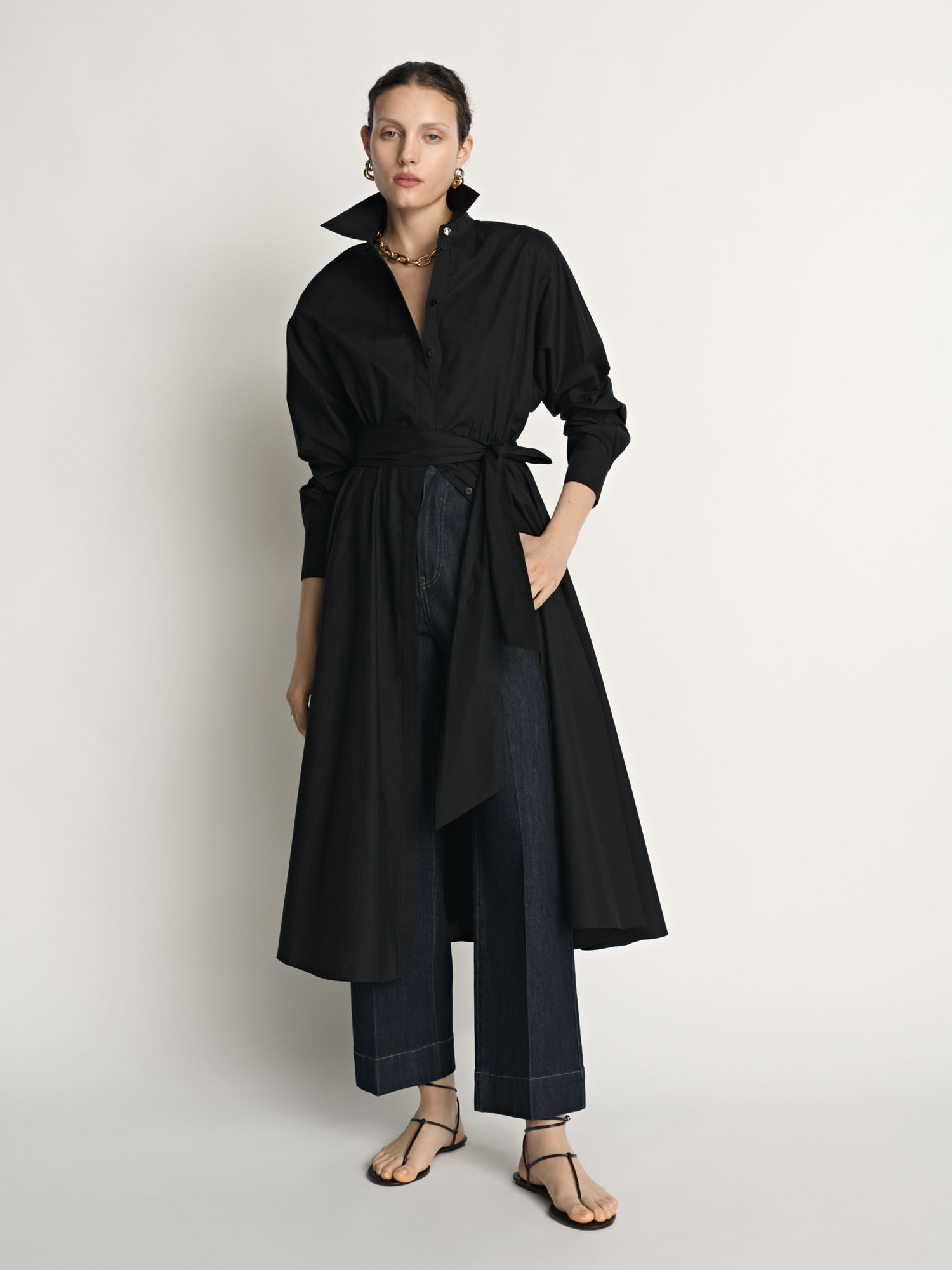 Model wearing a black Veronika Maine shirt dress styled open over wide-leg trousers for fashion e-commerce photography.