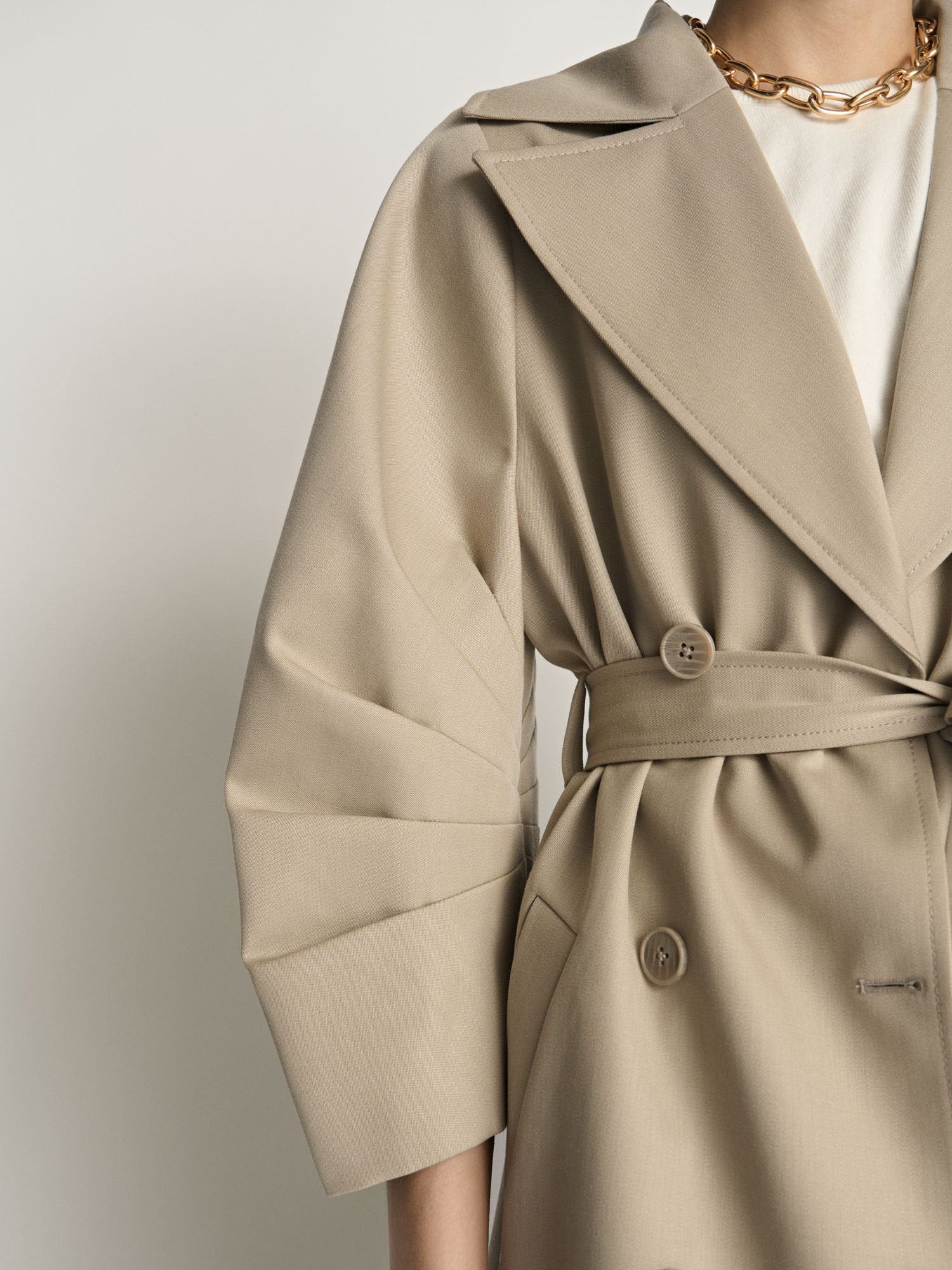 Close-up detail of a Veronika Maine trench coat sleeve photographed for fashion e-commerce.