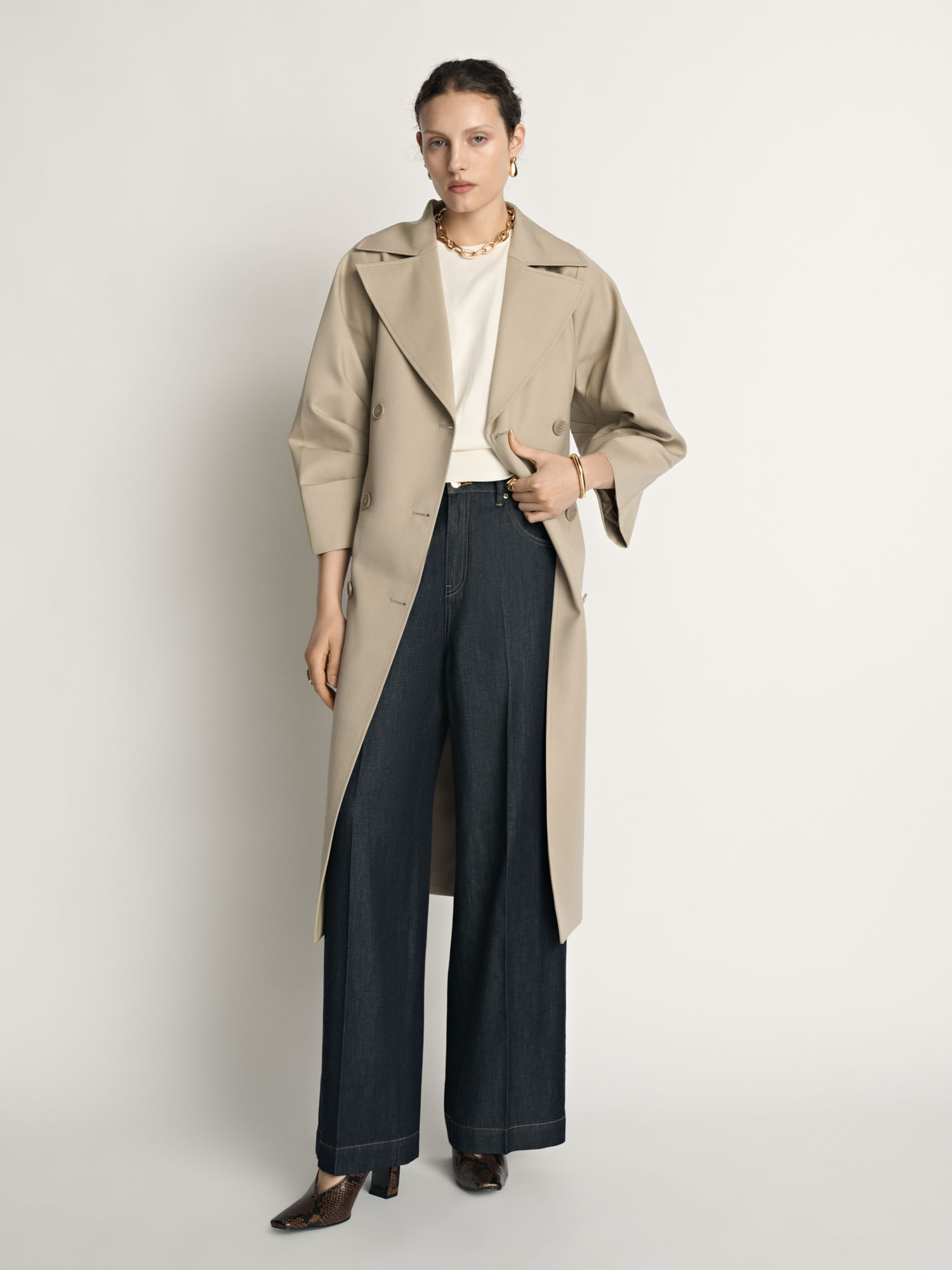 Model wearing an open Veronika Maine trench coat photographed for fashion e-commerce.