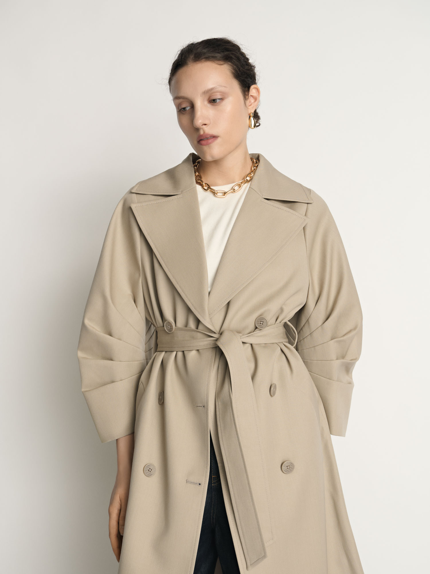 Three-quarter portrait of a model wearing a Veronika Maine trench coat photographed for fashion e-commerce.