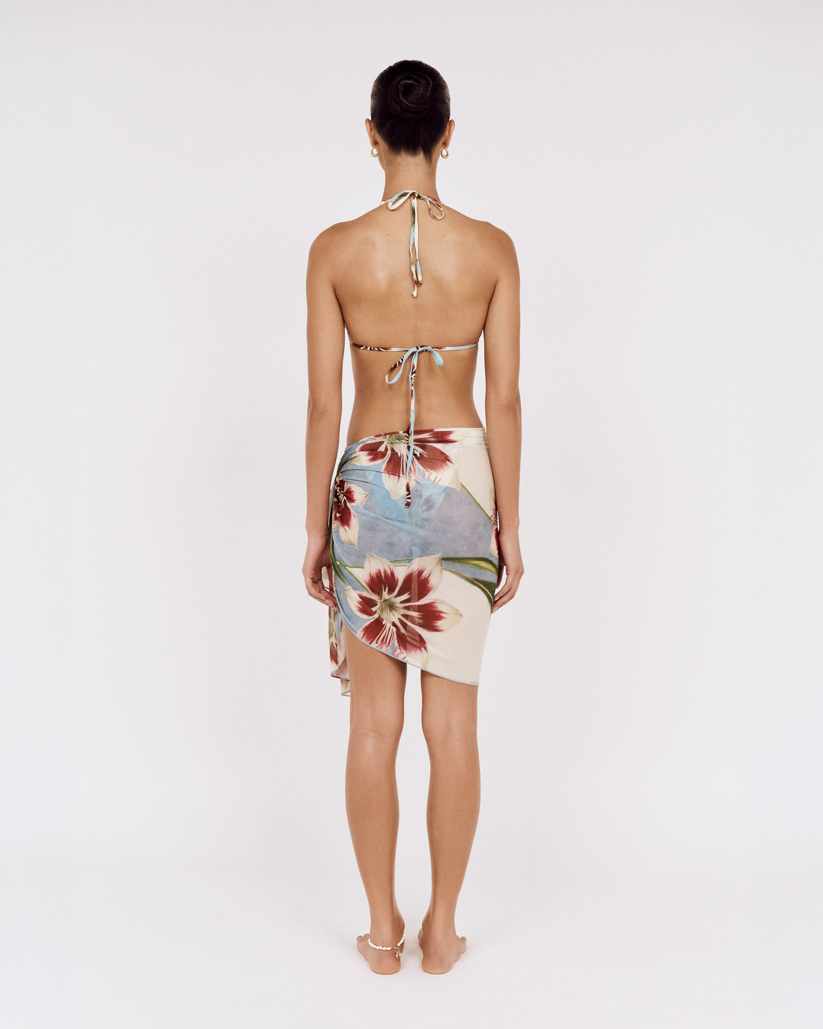 Back view of a model wearing a MINKPINK floral bikini with a matching sarong, photographed for fashion e-commerce by Shoot.Studio in Sydney.