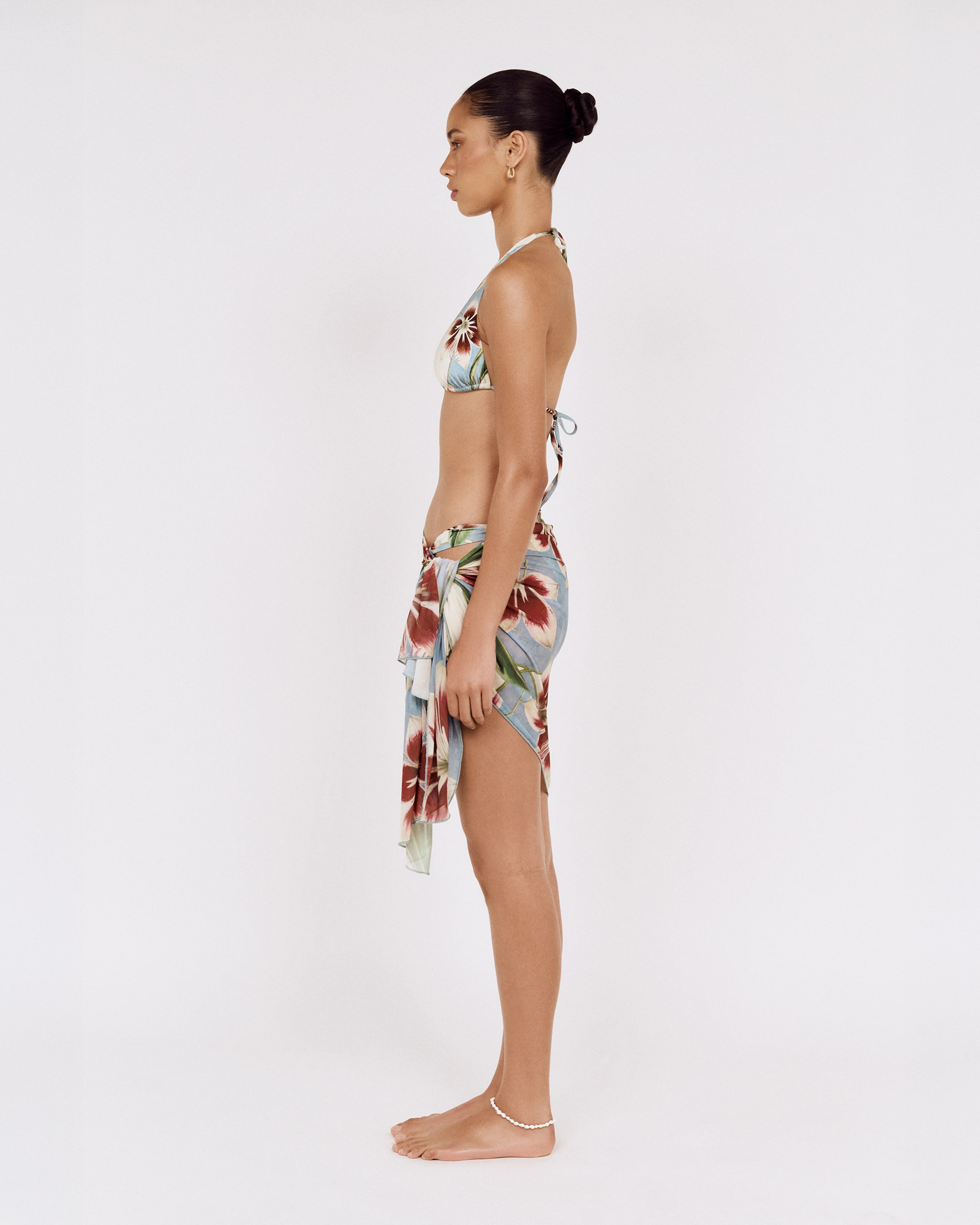 Side view of a model wearing a MINKPINK floral bikini with a matching sarong, photographed for fashion e-commerce by Shoot.Studio in Sydney.