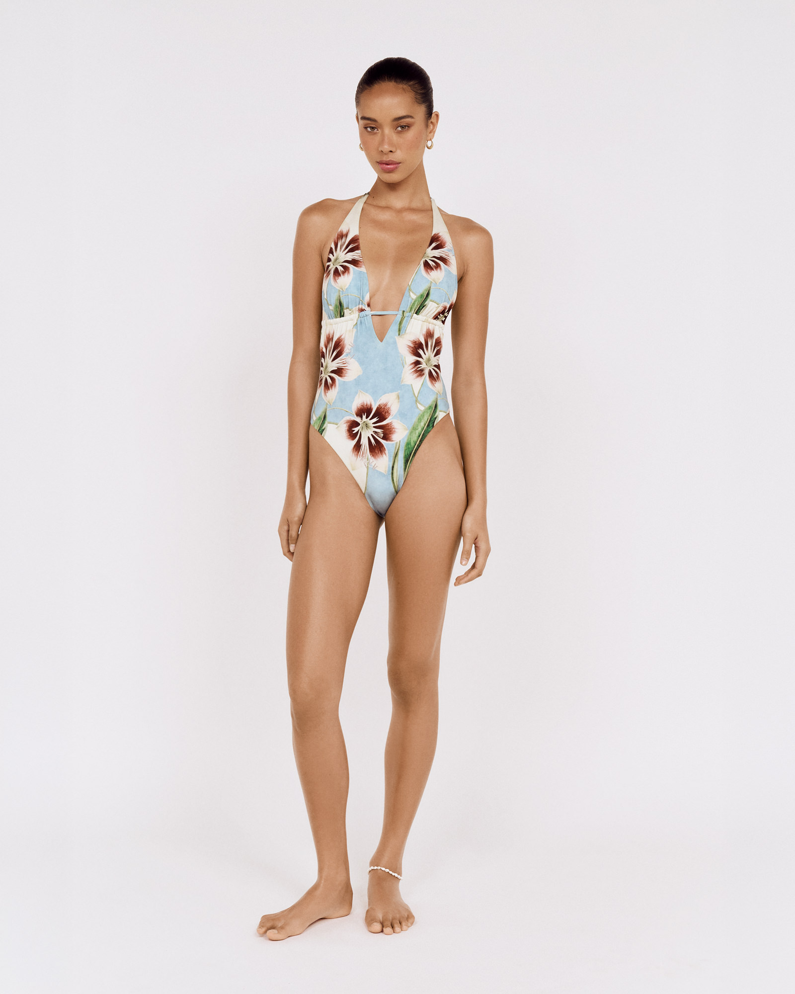Full-length front view of a model wearing a MINKPINK floral one-piece swimsuit, photographed for fashion e-commerce by Shoot.Studio in Sydney.