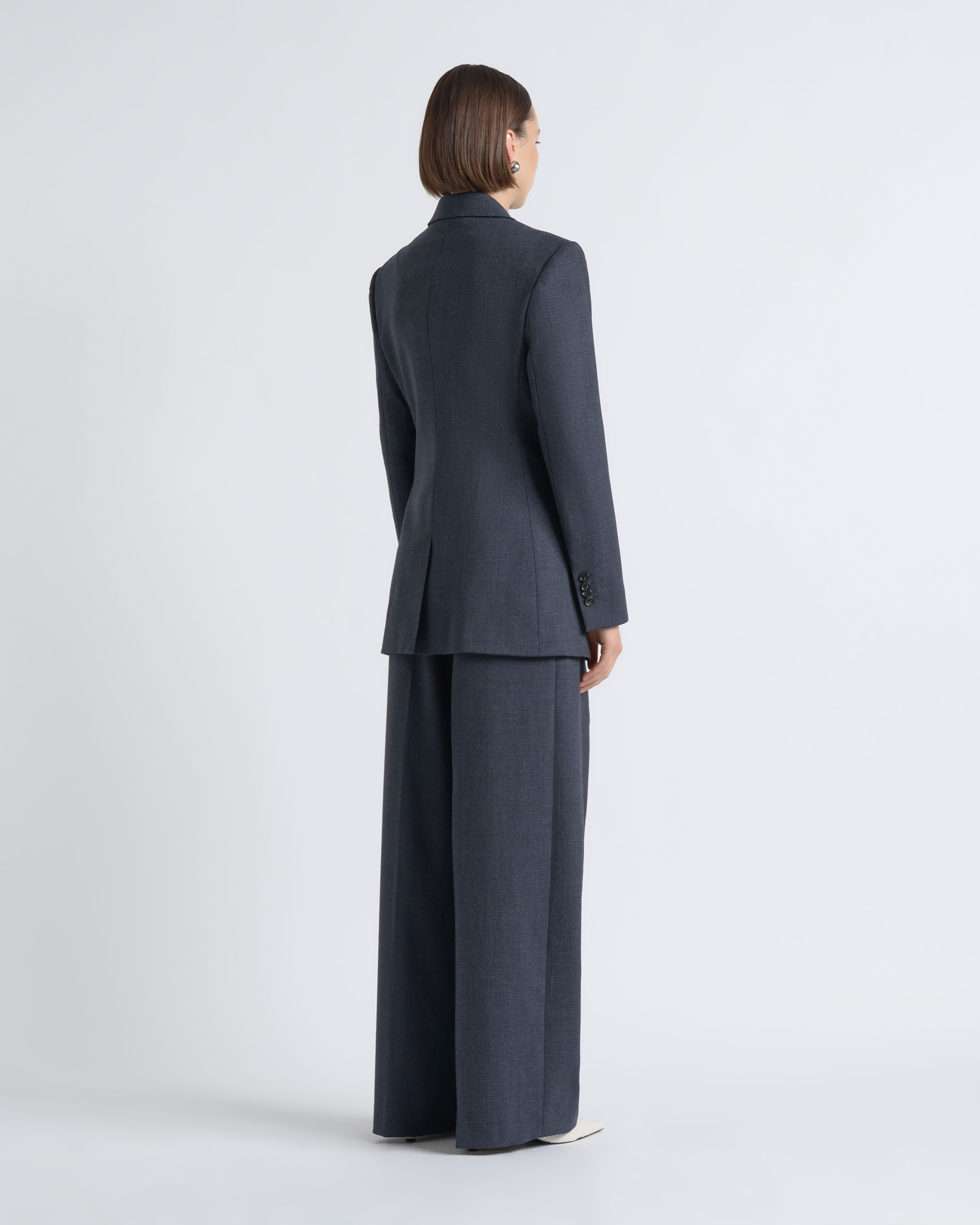 Back view of a model wearing a CUE charcoal blazer and wide-leg trousers.