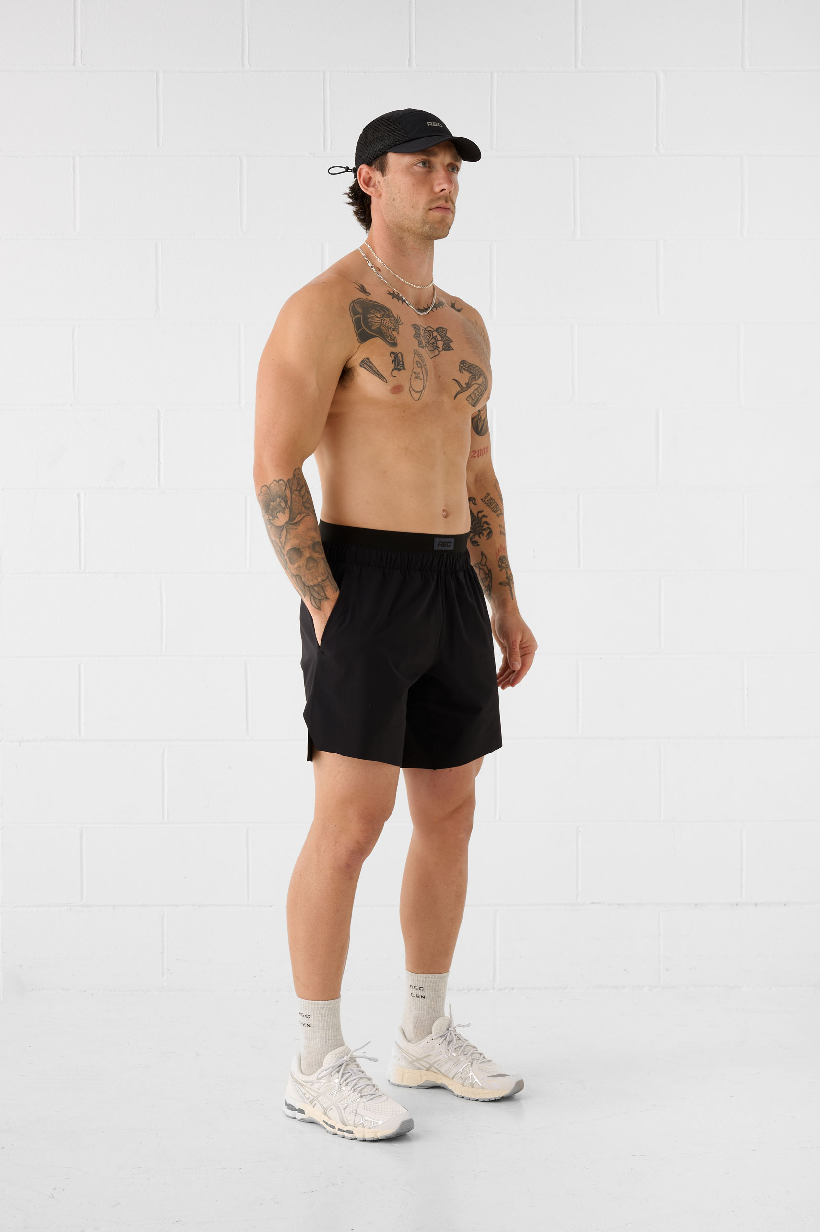 REC GEN men's black training shorts and cap, full-length side view