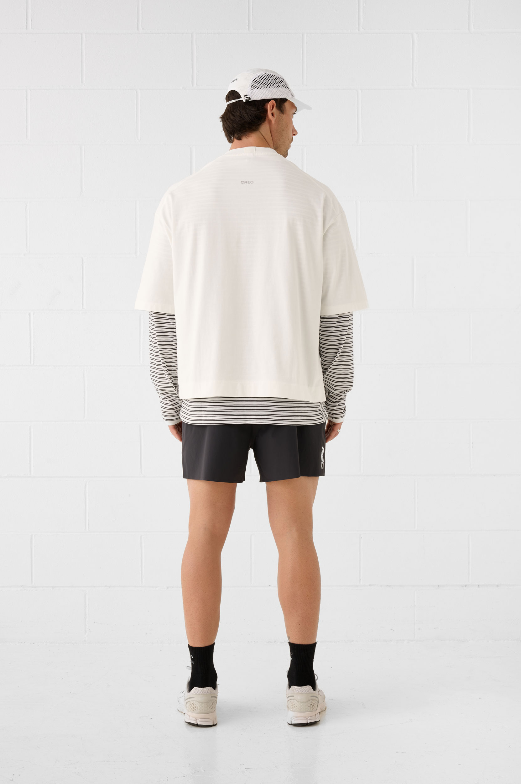 REC GEN men's off-white layered top and black shorts, full-length back view