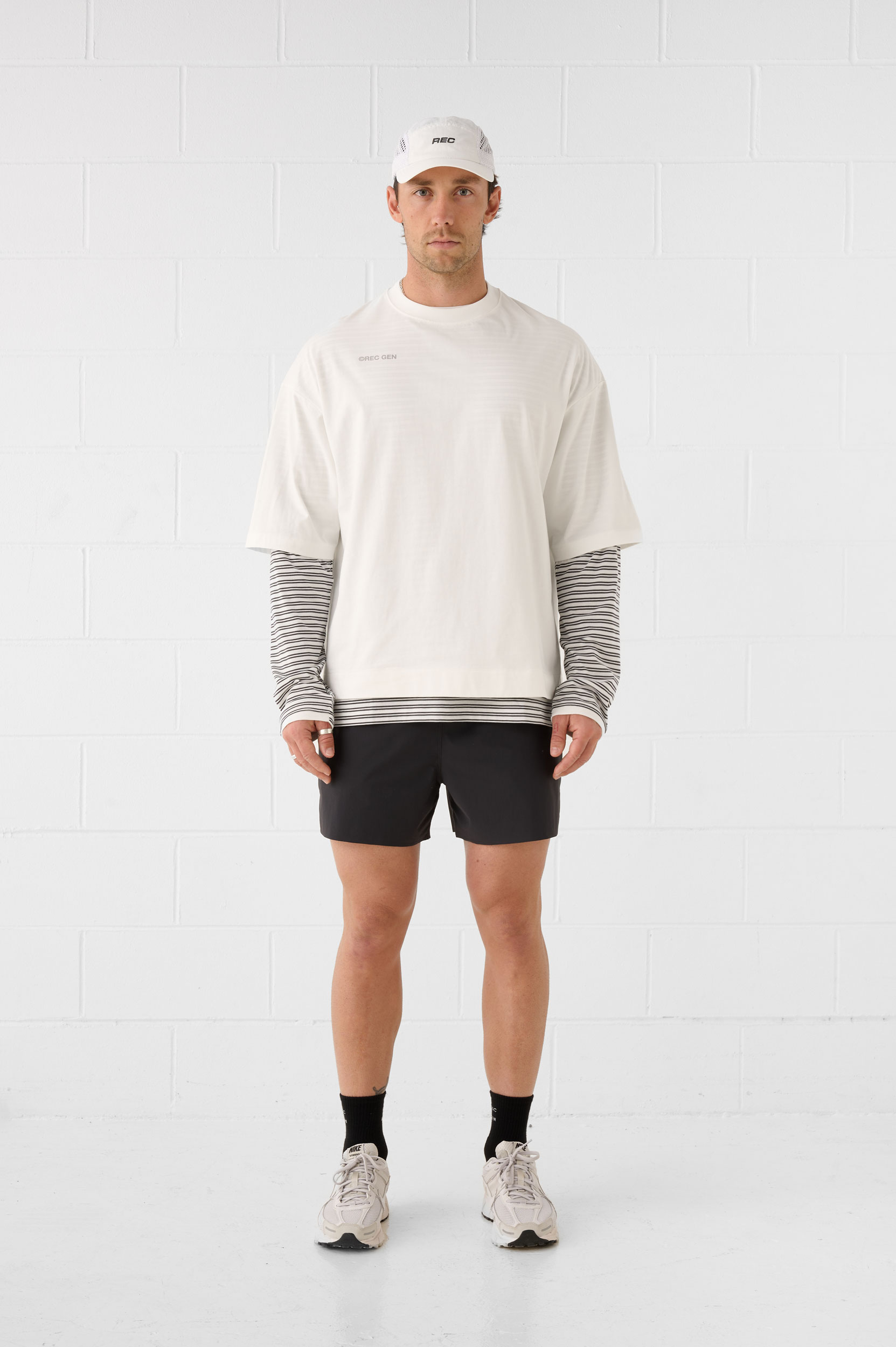 REC GEN men's off-white layered top and black shorts, full-length front view