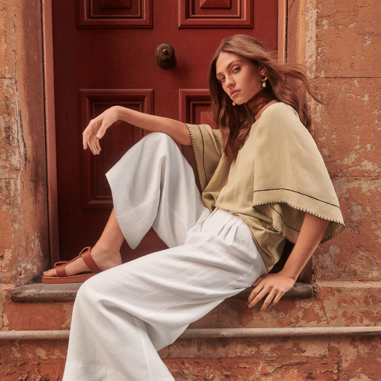 veronika-maine-fashion-campaign-beige-blouse-white-trousers-seated-2